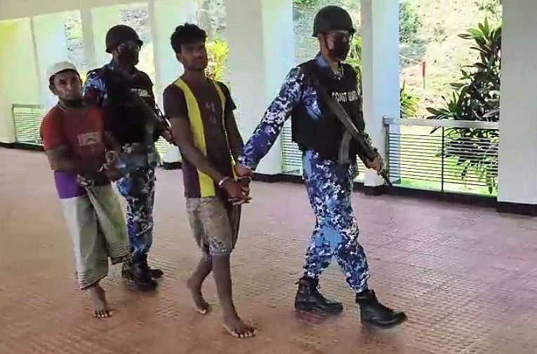 আটক ব্যক্তিদের দুজনকে নিয়ে যাচ্ছে কোস্টগার্ড