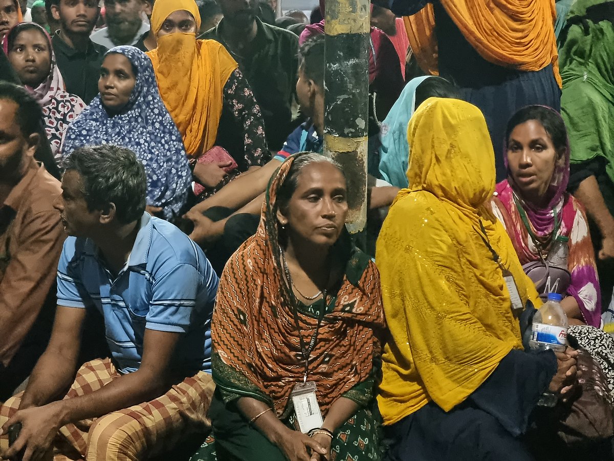 আইডি কার্ড গলায় শ্রমিক মিনারা বেগম। হাসিমুখে ঘরে ফিরতে চান।