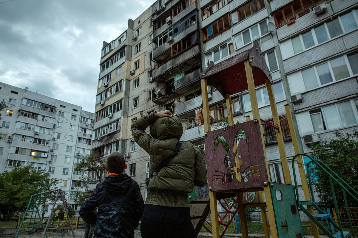 রাশিয়ার ড্রোন হামলায় ক্ষতিগ্রস্ত হয়েছে একটি আবাসিক ভবন। বাইরে থেকে ক্ষয়ক্ষতির  পরিমাণ দেখছেন ভবনটির দুই বাসিন্দা। আজ ইউক্রেনের রাজধানী কিয়েভে