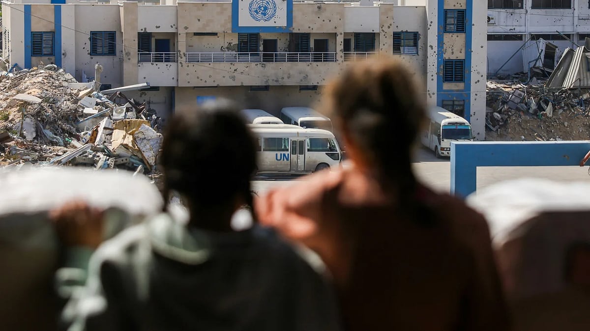 গাজা শহরে জাতিসংঘের ফিলিস্তিনি শরণার্থীদের জন্য কাজ করা সংস্থার (ইউএনআরডব্লিউএ) বন্ধ হয়ে যাওয়া প্রধান কার্যালয়ের সামনে দাঁড়িয়ে দুই শিশু