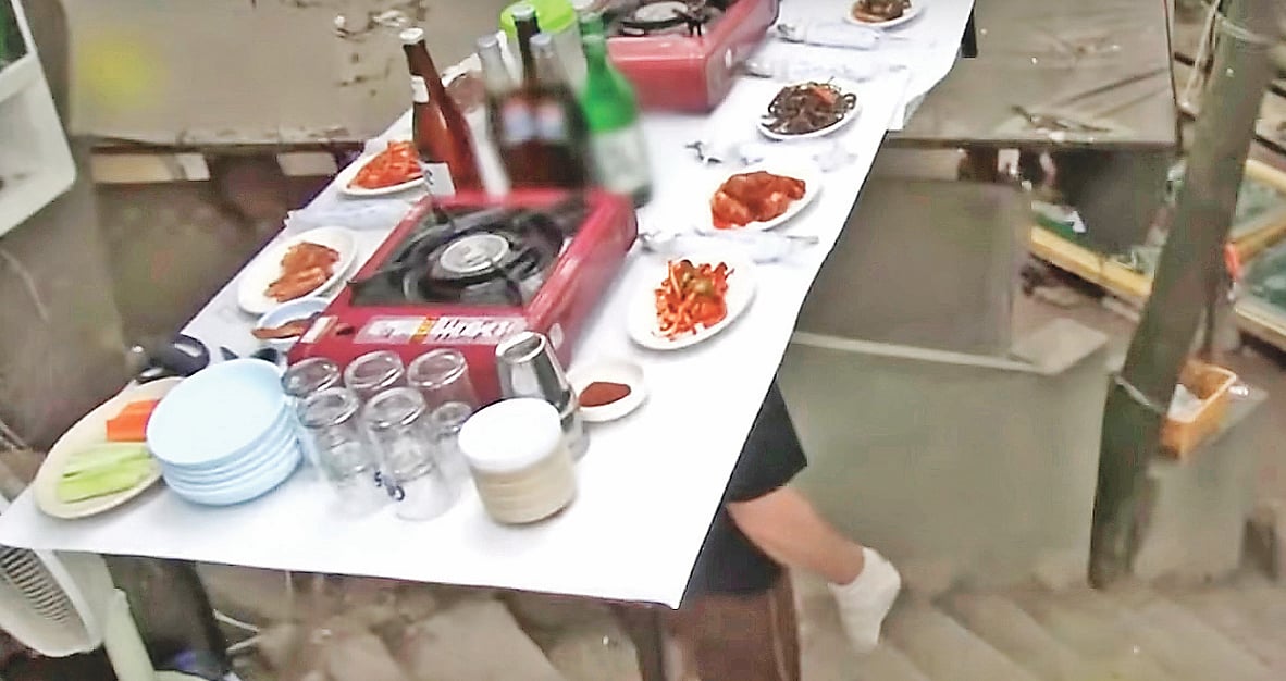 টেবিলভর্তি খাবার মাথায় নিয়ে চলছেন ক্যাং জিন-গিউ