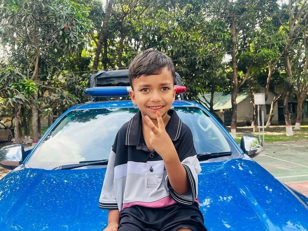 উদ্ধারের পর পুলিশের গাড়িতে বসে বিজয় চিহ্ন দেখাচ্ছে শিশু মো. আলিফ