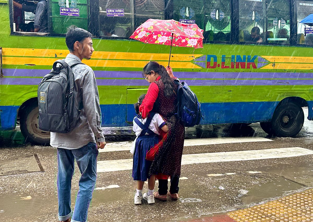বৃষ্টির মধ্যে সন্তানকে স্কুলে নিয়ে যাচ্ছেন অভিভাবক। আজ বৃহস্পতিবার সকালে আসাদ গেট থেকে তোলা
