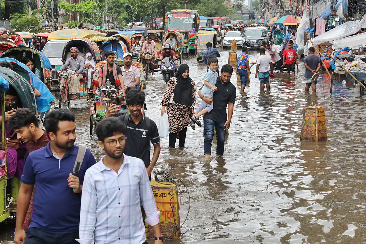 জলাবদ্ধতার মধ্যে ভোগান্তি নিয়ে চলাচল করছেন পথচারীরা। শুক্রবার মিরপুরে