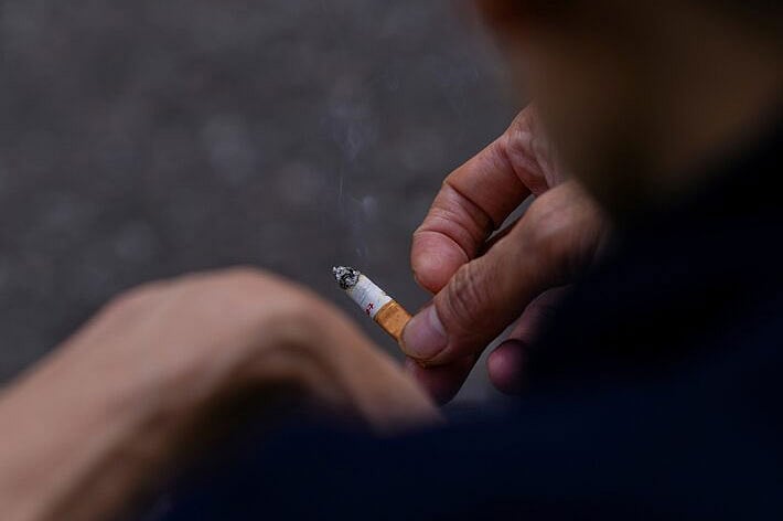 সিগারেট হাতে এক ব্যক্তি। লন্ডনে, ১১ এপ্রিল ২০২৩ সালে