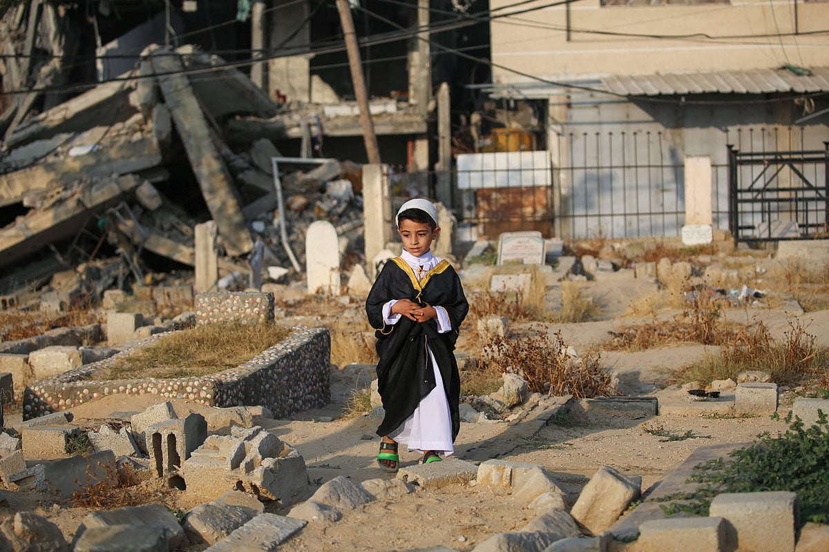 ঈদের নামাজ পড়ার পর গাজার এক শিশু নিহত স্বজনদের কবর জিয়ারত করছে।