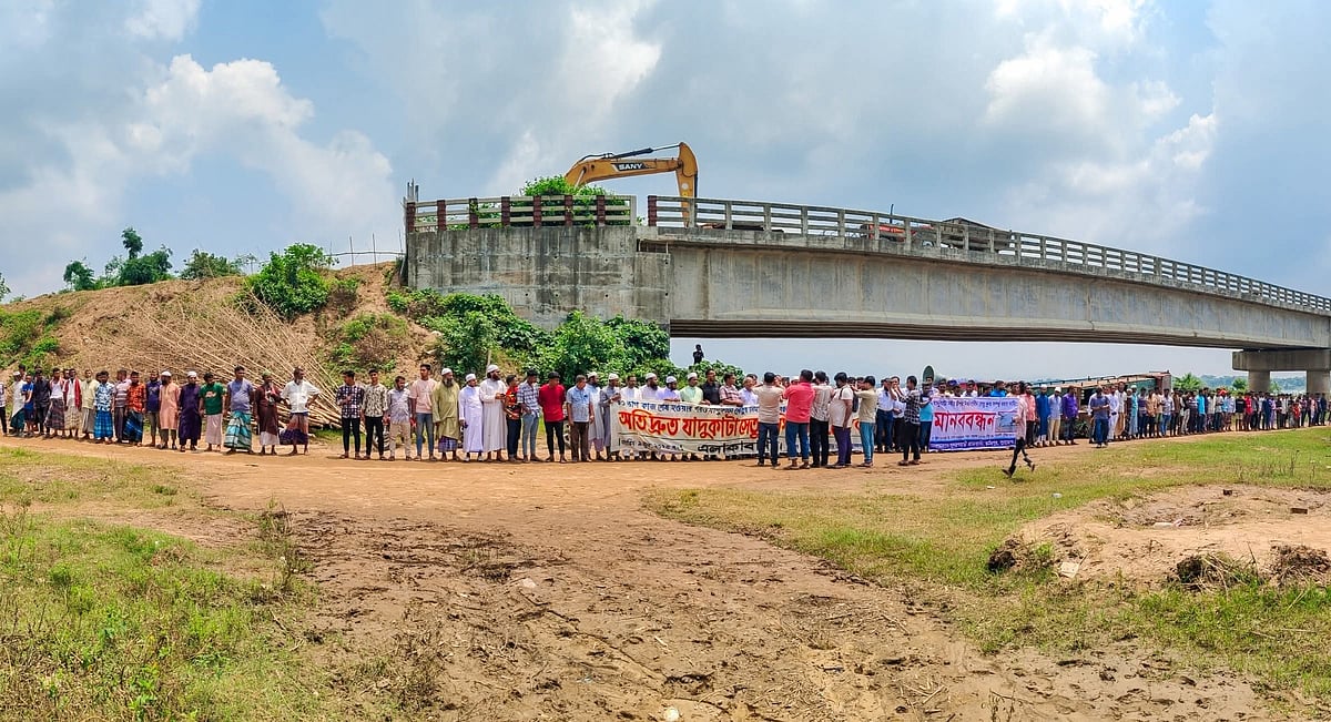 সুনামগঞ্জের যাদুকাটা নদীর ওপর নির্মাণাধীন সেতুর কাজ সাত বছরেও শেষ না হওয়ায় এলাকাবাসীর মানববন্ধন। সোমবার দুপুরে সেতুর পাশে গড়কাটি এলাকায়