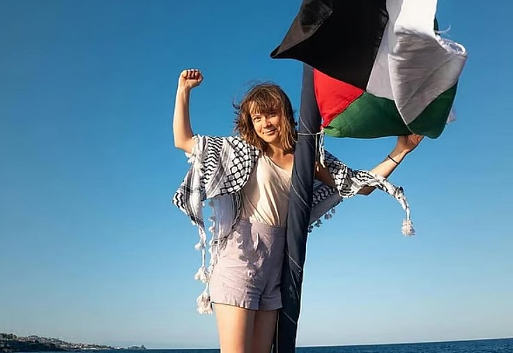 ম্যাডলিন জাহাজে ফিলিস্তিনি ‘কেফিয়াহ’ পরে ও ফিলিস্তিনের পতাকা হাতে গ্রেটা