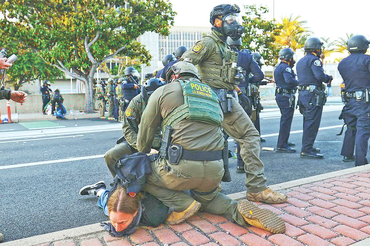 এক বিক্ষোভকারীকে গ্রেপ্তারের চেষ্টায় আইনশৃঙ্খলা বাহিনীর সদস্যরা। সোমবার ক্যালিফোর্নিয়ার সান্তা অ্যানা শহরে