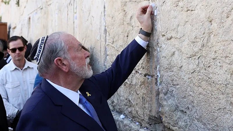 ওয়েস্টার্ন ওয়ালের ফাঁকে চিরকুট গুঁজে দিচ্ছেন ইসরায়েলে নিযুক্ত মার্কিন রাষ্ট্রদূত মাইক হাকাবি। তিনি বলেন, এই চিরকুট প্রেসিডেন্ট ডোনাল্ড ট্রাম্পের পাঠানো। ওল্ড সিটি, জেরুজালেম, ১৮ এপ্রিল ২০২৫