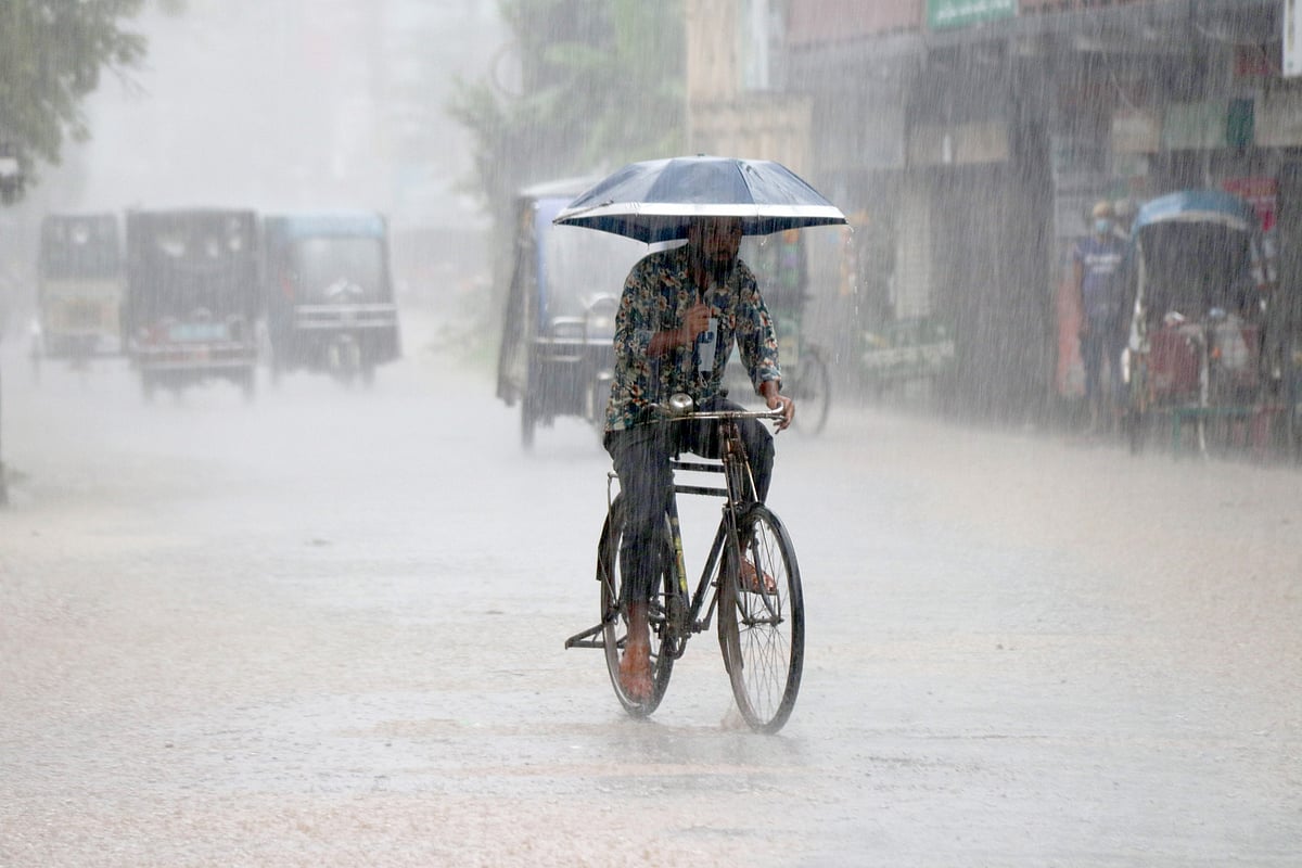 নেমেছে ঝুম বৃষ্টি। এর মধ্যেই ছাতা মাথায় সাইকেল চালিয়ে গন্তব্যে যাচ্ছেন এক ব্যক্তি