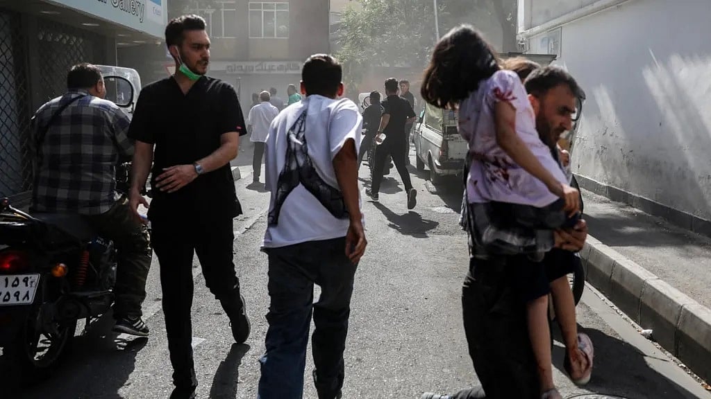 ইসরায়েলি হামলার পর তেহরানের রাস্তায় ধোঁয়ার মধ্যে মানুষ জড়ো হয়েছে। ১৫ জুন ২০২৫