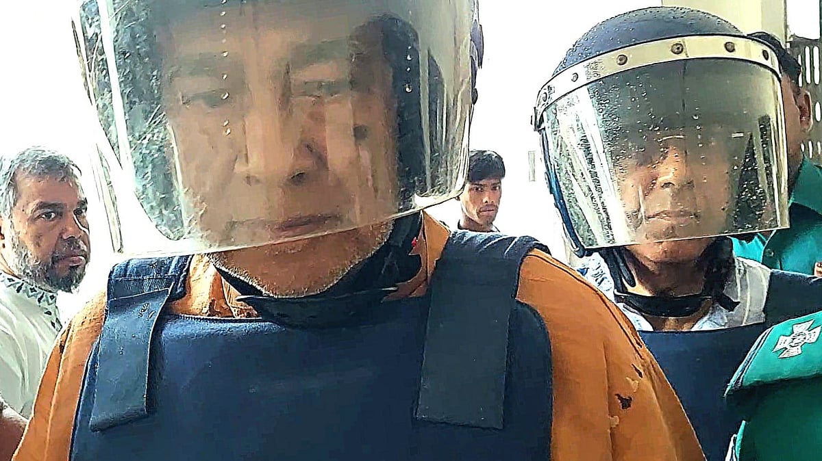 সাবেক মন্ত্রী মোশাররফ হোসেন (সামনে) ও আনিসুল হককে (পেছনে) হাজতখানা থেকে আদালতে নিয়ে যাচ্ছে পুলিশ