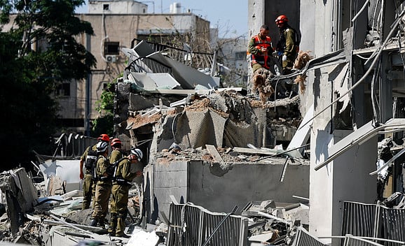 ইরানের ছোড়া ক্ষেপণাস্ত্রের আঘাতে বিধ্বস্ত ইসরায়েলের ভবন। ঘটনাস্থলে জরুরি উদ্ধারকর্মীদের তৎপরতা। গতকাল দেশটির রামাত গান এলাকায়