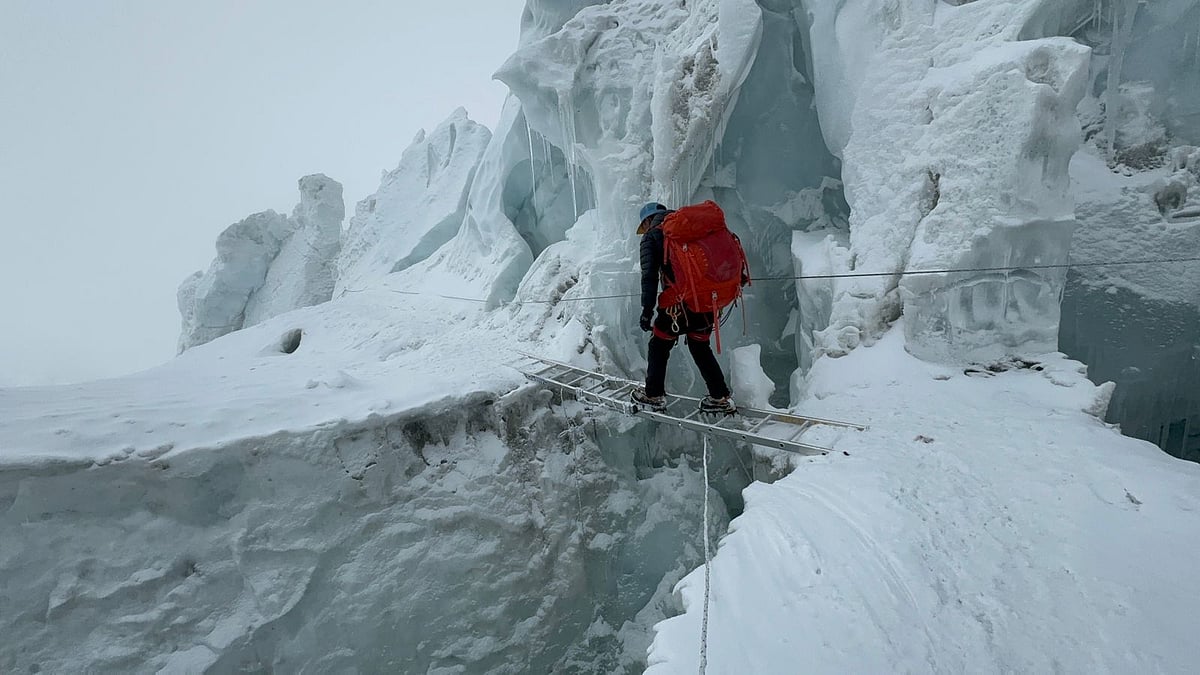 মই ব্যবহার করে ক্রিভাস পার হচ্ছেন এক পর্বতারোহী