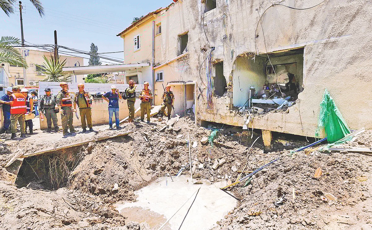 ইরানের হামলায় ক্ষতিগ্রস্ত হয়েছে এই বাড়ির একাংশ। বাড়ির পাশেই ক্ষেপণাস্ত্রের আঘাতে সৃষ্টি হয়েছে গর্ত। হামলার পর সেখানে যান ইসরায়েলের সেনা ও দেশটির জরুরি সেবা বিভাগের কর্মীরা। গতকাল ইসরায়েলের বেইত শেয়ান এলাকায়