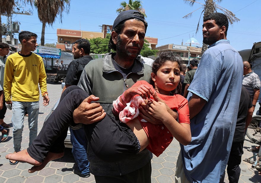 ইসরায়েলি হামলায় আহত শিশুকন্যাকে চিকিৎসার জন্য হাসপাতালে নিয়ে যাচ্ছেন এক ফিলিস্তিনি। গতকাল গাজার দেইর আল-বালাহতে
