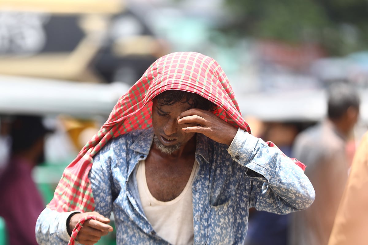 প্রখর রোদ আর গরমে হাঁপিয়ে উঠেছেন রিকশাচালক। মাথায় গামছা দিয়ে রোদ ঠেকানোর চেষ্টা।