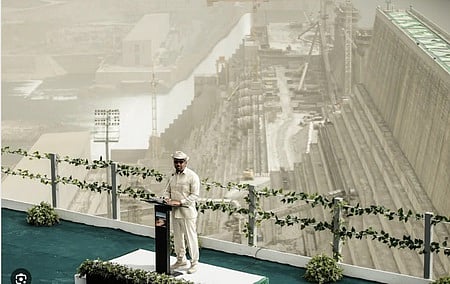 গ্র্যান্ড রেনেসাঁ বাঁধের ছবির সামনে দাঁড়িয়ে বক্তব্য দিচ্ছেন ইথিওপিয়ার প্রধানমন্ত্রী আবি আহমেদ