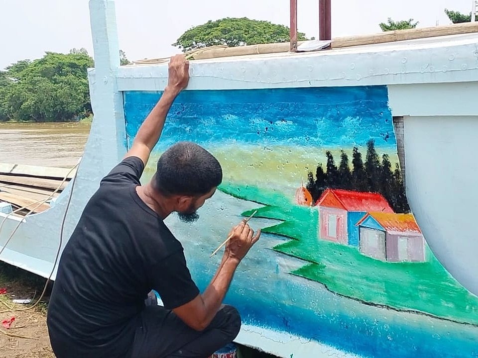 একটি যাত্রীবাহী ট্রলারে ছবি আঁকছেন তমজিদ উদ্দিন। সম্প্রতি মদন উপজেলার বাঁশরী গ্রামে