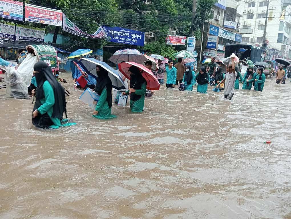 বৃষ্টিতে হাঁটু থেকে কোমরপানি জমেছে ফেনী শহরের শহীদ শহীদুল্লা কায়সার সড়কে। পানি মাড়িয়ে কলেজে যাচ্ছেন শিক্ষার্থীরা