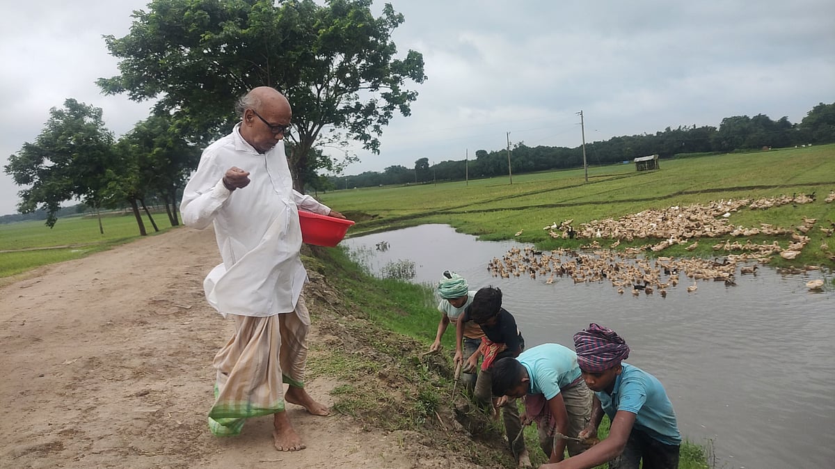 রাস্তার ধারে বৃক্ষের বীজ ছিটাচ্ছেন বৃক্ষপ্রেমী কার্তিক পরামানিক আর নিড়ানি দিয়ে গর্ত করে মাটিতে পুঁতে দিচ্ছে ছোট ছোট শিক্ষার্থীরা। মনোহরপুর সড়ক, মনাকষা, শিবগঞ্জ, চাঁপাইনবাবগঞ্জ