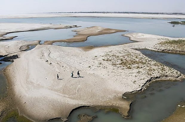 পাকিস্তান অংশে সিন্ধু নদের জেগে ওঠা চরে হাঁটছেন মানুষ। ১৫ মার্চ, জমশোরো