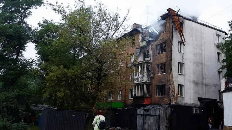 রাশিয়ার ড্রোন হামলায় কিয়েভের ক্ষতিগ্রস্ত একটি আবাসিক ভবনের দিকে তাকিয়ে আছেন এক নারী