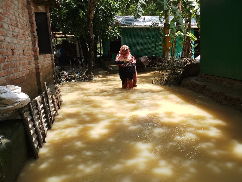 বন্যার পানি মাড়িয়ে চলাচল করছেন এক বাসিন্দা। ফেনীর ফুলগাজী উপজেলার উত্তর শ্রীপুর গ্রামের পূর্ব পাড়া এলাকায়। আজ সকালে