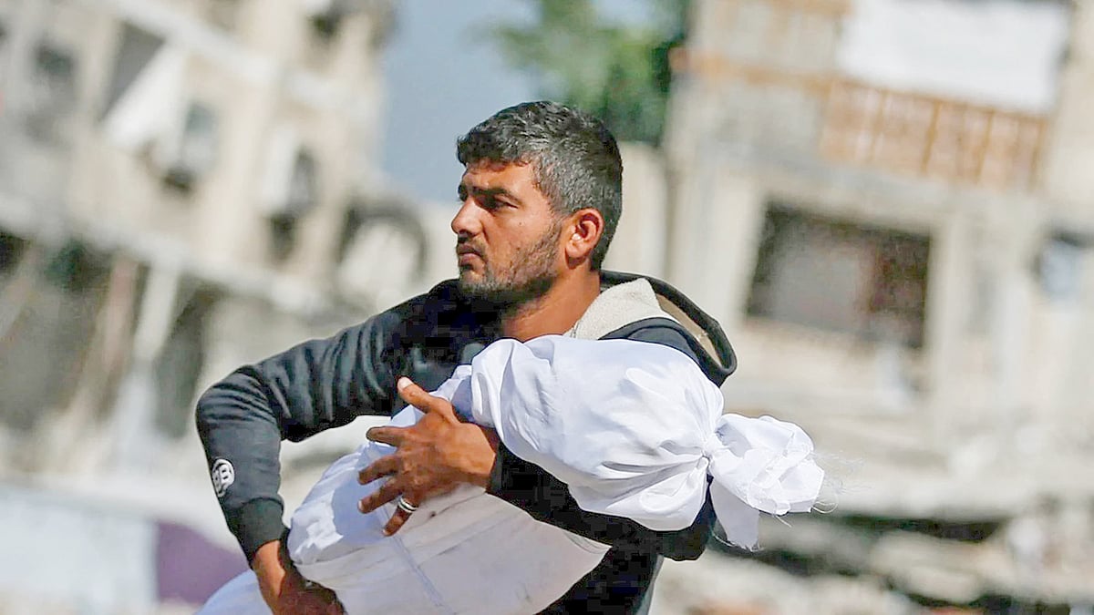 ইসরায়েলি হামলায় নিহত শিশুর মরদেহ নিয়ে যাচ্ছেন ফিলিস্তিনি বাবা