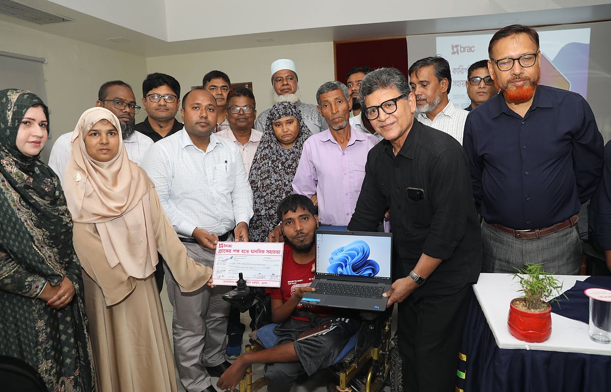 সুজন মোহাম্মদ এলাহী হোসেনের হাতে টাকা ও ল্যাপটপ তুলে দিচ্ছেন ব্র্যাকের চেয়ারপারসন হোসেন জিল্লুর রহমান। আজ বৃহস্পতিবার বগুড়ার শাজাহানপুর উপজেলার বেতগাড়ি এলাকায় ব্র্যাকের লার্নিং সেন্টারে