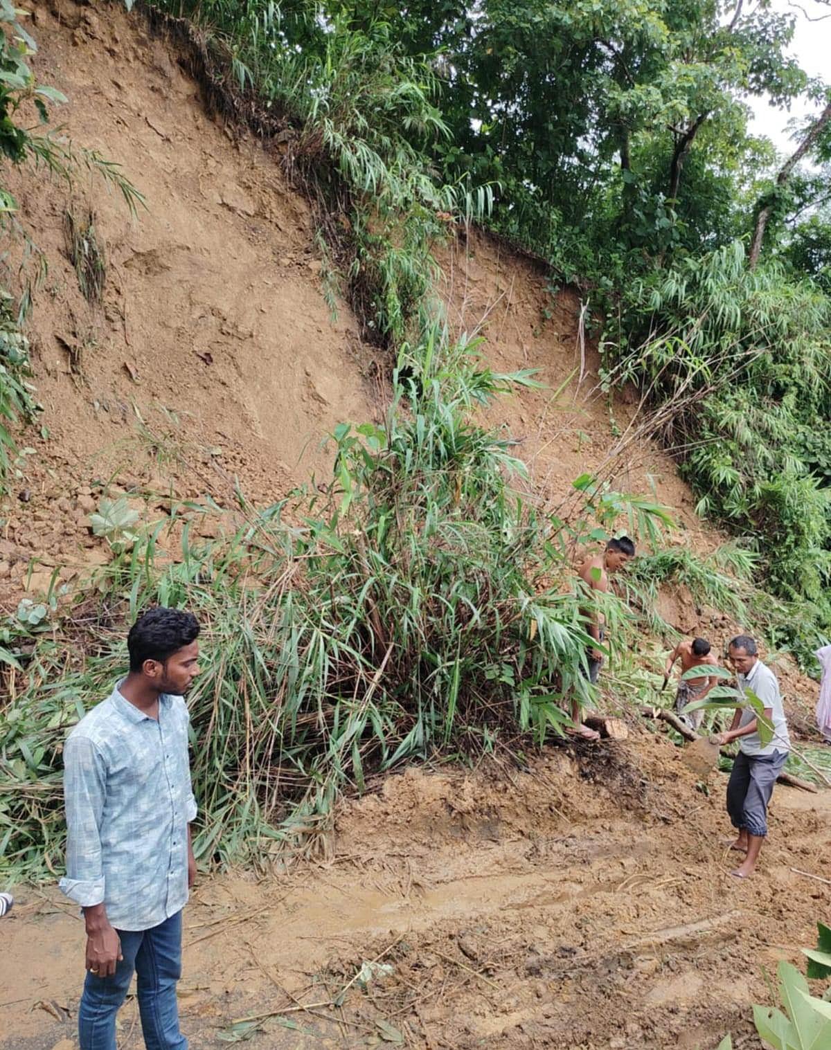 ধসে পড়া পাহাড়ের মাটি সরিয়ে নিতে কাজ করছেন কয়েকজন বাসিন্দা। আজ সকালে তোলা