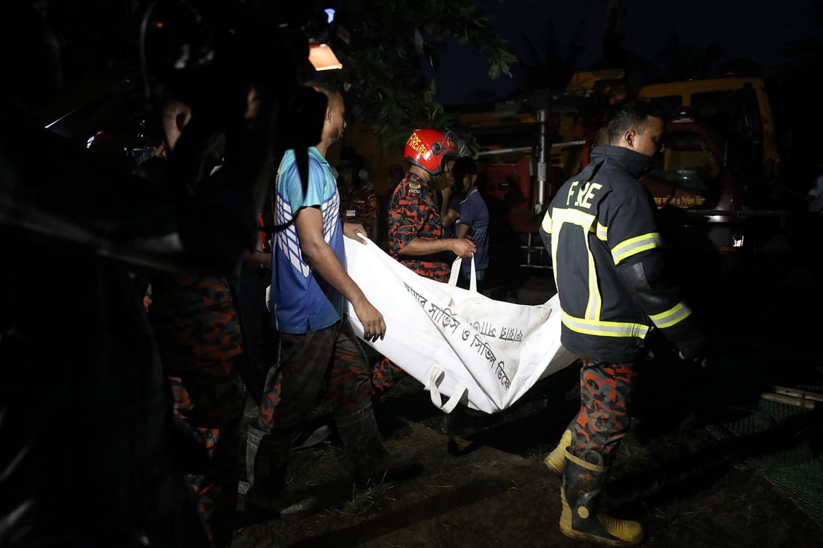 রাজধানীর উত্তরায় মাইলস্টোন স্কুল অ্যান্ড কলেজে বিমান বিধ্বস্ত হয়ে নিহত একজনের লাশ উদ্ধার করে নিচ্ছেন ফায়ার সার্ভিসের কর্মীরা