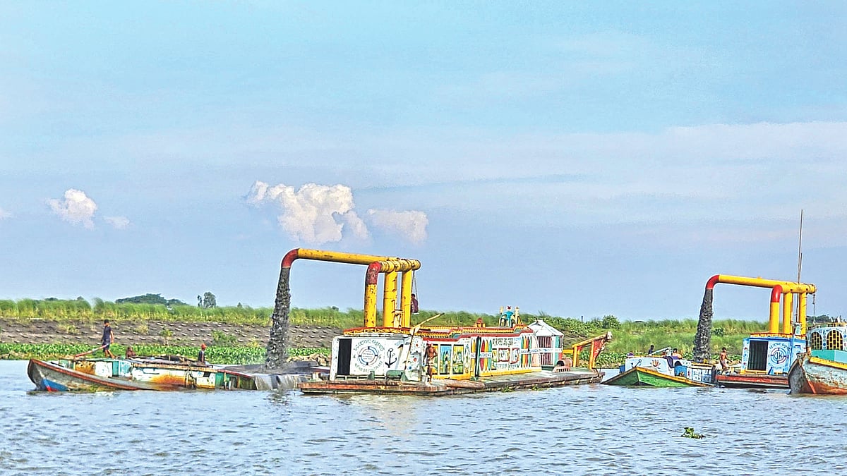 বাঁধ ঘেঁষে ড্রেজার দিয়ে কাটা হচ্ছে বালু। গত সোমবার দুপুরে মুন্সিগঞ্জের গজারিয়া
উপজেলার ষোলআনি এলাকায়