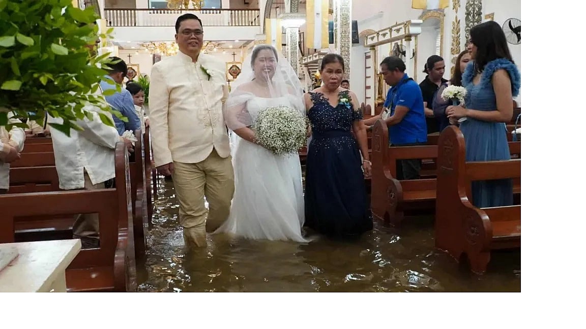 পানির মধ্য দিয়ে বিয়ে করতে হেঁটে আসছেন বর–কনে