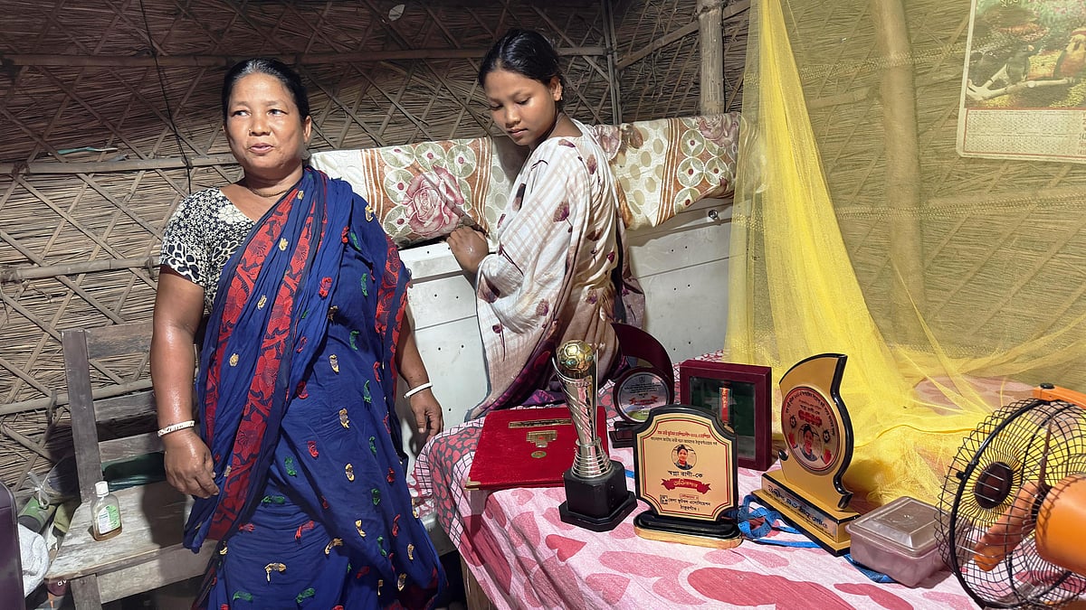 খেলাধুলায় পাওয়া মেয়ে স্বপ্না রানীর ছবি-পুরস্কার ও ট্রফিগুলো দেখাচ্ছেন মা ছবিলা রানী। গত বুধবার দুপুরে ঠাকুরগাঁওয়ের রানীশংকৈল উপজেলার শিয়ালডাঙ্গী গ্রামে