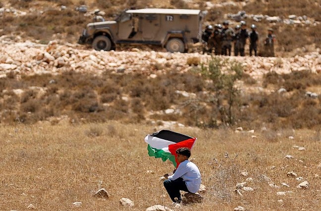 ইসরায়েল কর্তৃক ভূমি জবরদখলের বিরুদ্ধে ফিলিস্তিনি পতাকা হাতে এক কিশোরের প্রতিবাদ। ১৮ জুলাই, পশ্চিম তীরের রাবা এলাকায়