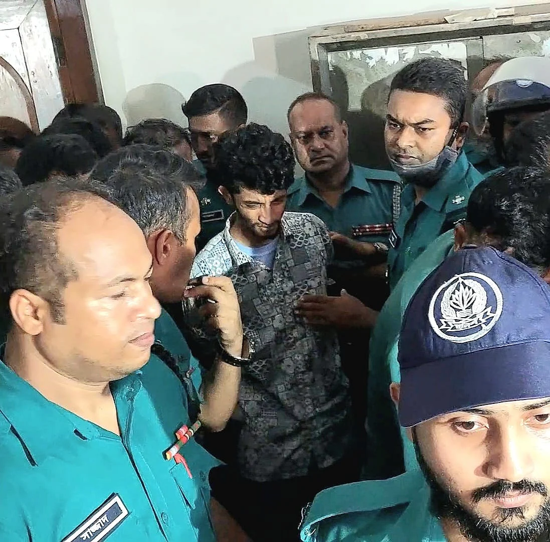 চাঁদাবাজির মামলায় গ্রেপ্তার বৈষম্যবিরোধী ছাত্র আন্দোলনের নেতা  আব্দুর রাজ্জাক বিন সোলাইমান ওরফে রিয়াদকে আদালত থেকে হাজতখানায় নিয়ে যাচ্ছে পুলিশ। গত রোববার বিকেলে ঢাকার সিএমএম আদালত প্রাঙ্গণে  