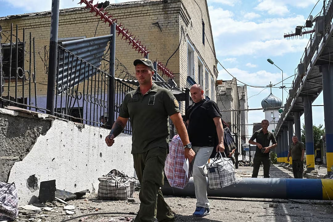 রাশিয়ার হামলার পর কারাগার থেকে এক বন্দীকে নিয়ে যাচ্ছেন ইউক্রেনের একজন সেনা। ইউক্রেনের জাপোরিঝঝিয়া অঞ্চলে, ২৯ জুলাই, ২০২৫