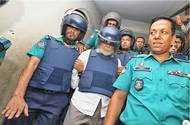 সাবেক প্রধান বিচারপতি এ বি এম খায়রুল হককে আদালত থেকে হাজতখানায় নেওয়া হচ্ছে।