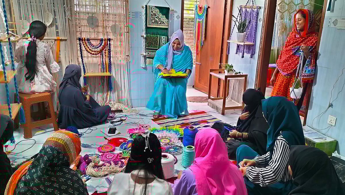 দিনাজপুর শহরের পশ্চিম রামনগর এলাকায় চতুর্ভুজের কারখানায় ড্রিমক্যাচার তৈরি করছেন নারীরা। পাশে বসে দেখিয়ে দিচ্ছেন প্রতিষ্ঠানের পরিচালক শামীমা নাছরিন। সম্প্রতি তোলা ছবি