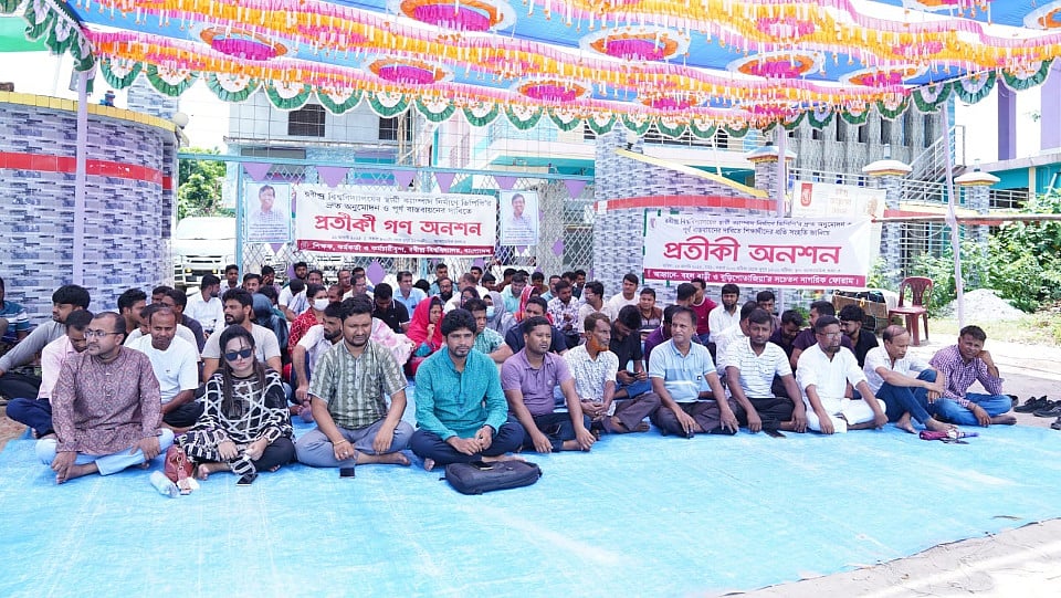 একনেক সভায় রবীন্দ্র বিশ্ববিদ্যালয়ের স্থায়ী ক্যাম্পাস নির্মাণ প্রকল্পের ডিপিপি অনুমোদনের দাবিতে প্রতীকী গণ–অনশনে শিক্ষক–শিক্ষার্থী ও কর্মকর্তা–কর্মচারীরা। শনিবার শাহজাদপুর পৌর শহরের অস্থায়ী একাডেমিক ভবন–৩–এর সামনে