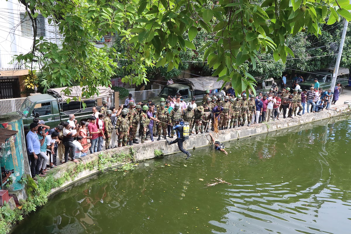 রাজশাহী নগরের কাদিরগঞ্জে পুকুরে অনুসন্ধানে নেমেছেন ডুবুরিরা। আজ শনিবার দুপুরে