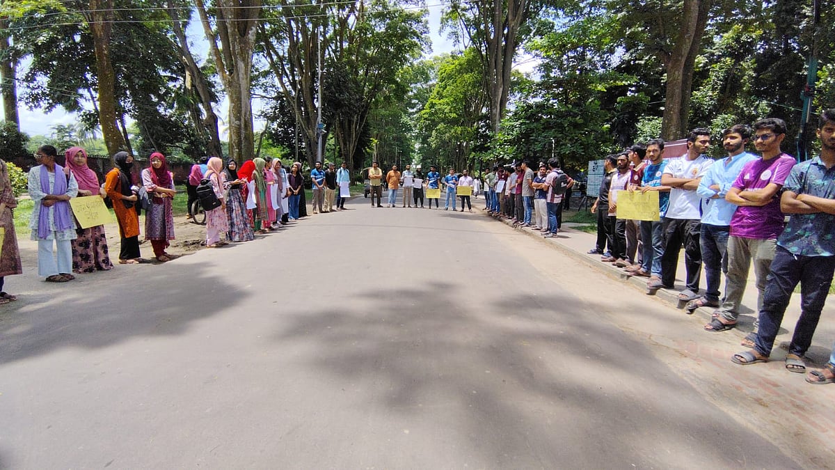 রাজশাহী বিশ্ববিদ্যালয়ে ছাত্রীকে যৌন হয়রানির অভিযোগে শিক্ষকের শাস্তির দাবিতে মানববন্ধন।  সোমবার দুপুরে বিশ্ববিদ্যালয়ের প্যারিস রোডে