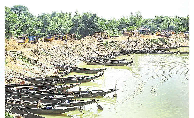 সিলেটের জৈন্তাপুর উপজেলার বড়গাং নদের ইজারাবহির্ভূত স্থান থেকে বালু উত্তোলন চলছে। সেই বালু রাখা হয়েছে ফেরিঘাট এলাকায়। সেখান থেকে ট্রাকে করে বিক্রির জন্য নেওয়া হচ্ছে বিভিন্ন এলাকায়। সোমবার দুপুরে।