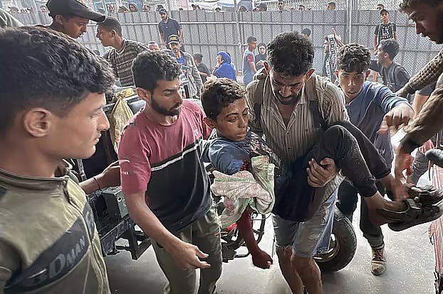 ফিলিস্তিনের গাজায় ত্রাণ সংগ্রহ করতে গিয়ে ইসরায়েলি সেনাদের গুলিতে আহত এক শিশুকে হাসপাতালে আনা হচ্ছে