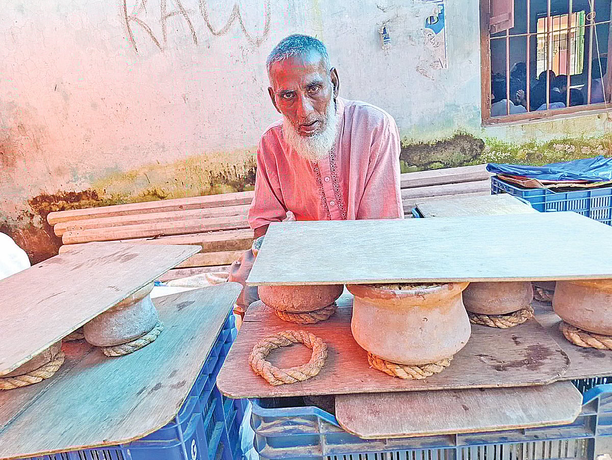 ‘ভালো মানুষের’ দইয়ের দোকানে বসে আছেন মুজিবুর রহমান। বৃহস্পতিবার নওগাঁর বদলগাছী উপজেলার পারসোমবাড়ি বাজারে