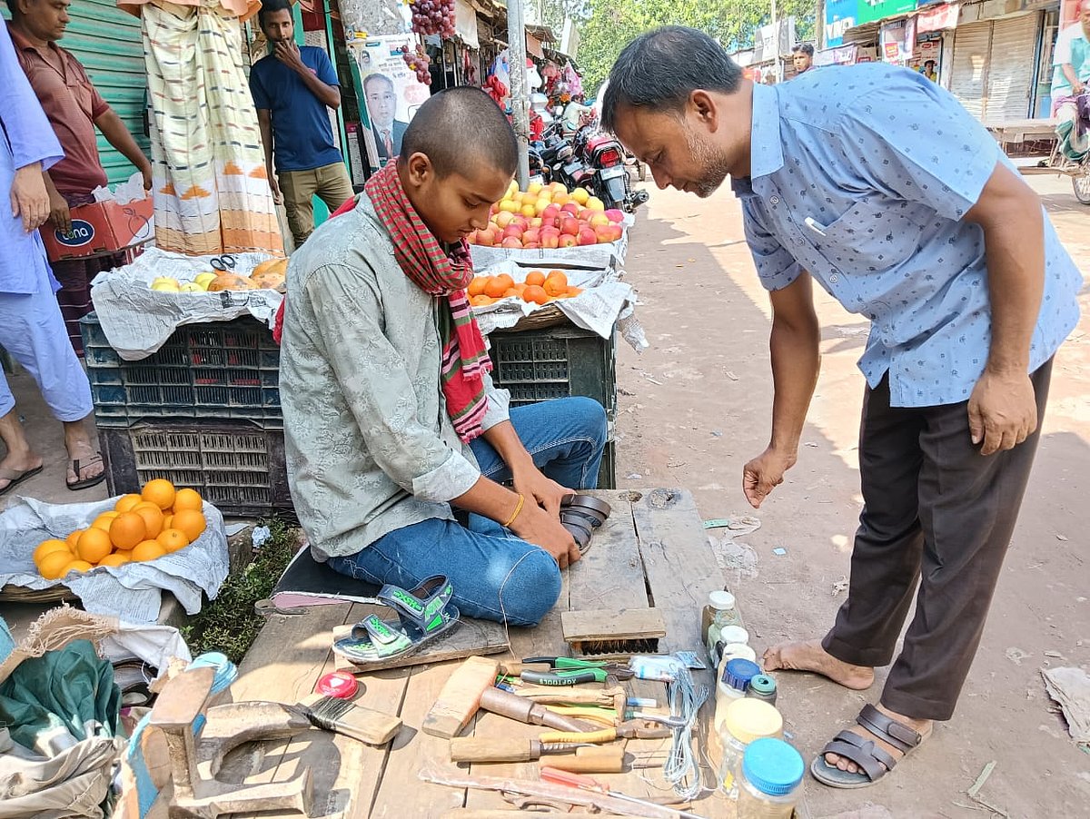 রংপুরের তারাগঞ্জ বাজারে জুতা সেলাইয়ের কাজ করছে পিটিয়ে হত্যা করা রূপলালের ছেলে জয় দাস।