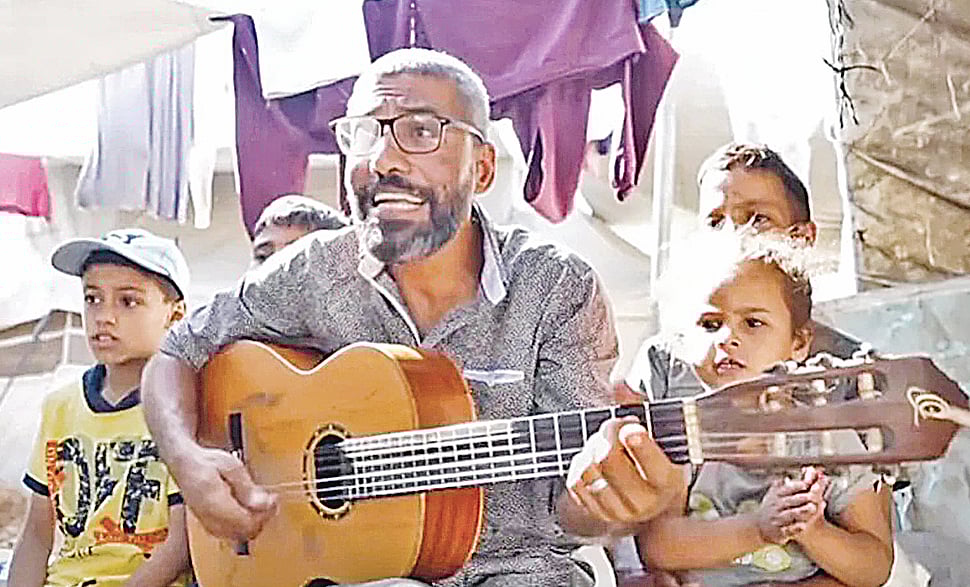 শিশুদের নিয়ে গান করছেন গাজার  সংগীতশিক্ষক আহমেদ আবু আমশা