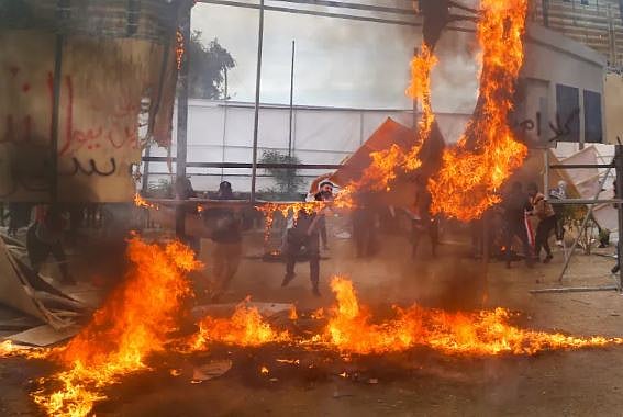 পিএমএফের সদস্যরা বাগদাদে যুক্তরাষ্ট্রের দূতাবাসের সামনে বিক্ষোভের সময় একটি বড় পোস্টারে আগুন ধরিয়ে দেয়। ঘটনাটি ২০২১ সালের।
